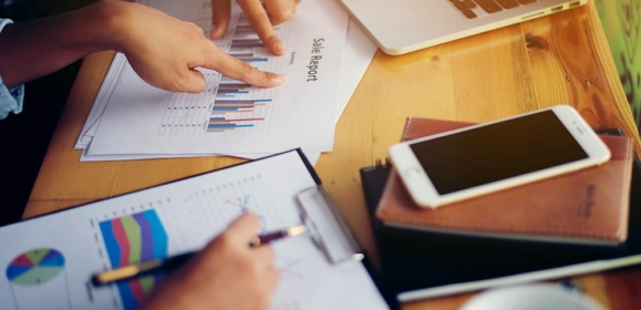 Business team meeting analysis financial chart together at cafe.